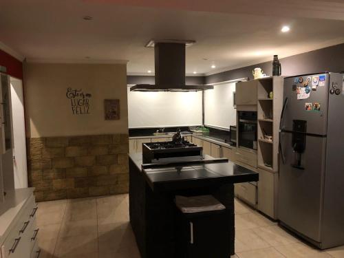 una cocina con fregadero y refrigerador en Casa, en San Bernardo