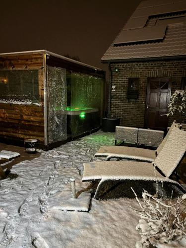 a patio with two lounges and a green light at Mon petit cocon in Jalhay