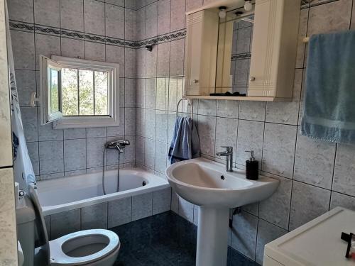 a bathroom with a sink and a toilet and a tub at Ελαια in Marathopolis