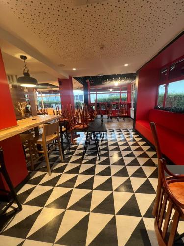 a restaurant with a checkered floor and tables and chairs at ibis Strasbourg Sud La Vigie in Ostwald