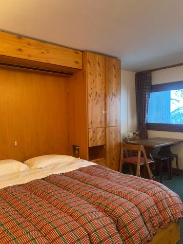 a bedroom with a bed and a desk and a table at Monolocale Cielo Alto Breuil-Cervinia in Breuil-Cervinia