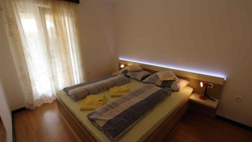 duże łóżko w pokoju z oknem w obiekcie Malinska Apartment 2 w mieście Sveti Anton