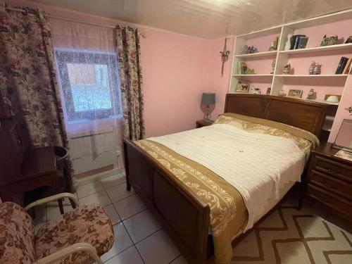 une chambre avec un lit, une chaise et une fenêtre dans l'établissement Bienvenue, à Saint-Dalmas-le-Selvage