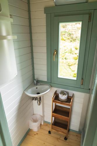 une salle de bain avec un lavabo et une fenêtre dans l'établissement Roulottes et son kota grill sauna, à Bucilly