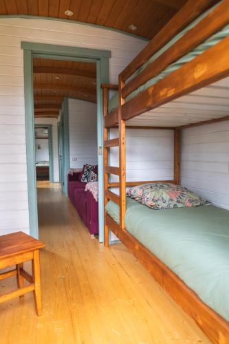 une chambre avec deux lits superposés et une table dans l'établissement Roulottes et son kota grill sauna, à Bucilly
