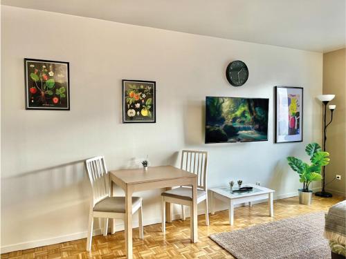 une salle à manger avec une table, des chaises et une horloge dans l'établissement Logement rénové proche centre-ville Lyon, à Villeurbanne