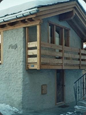 a building with a balcony on the side of it at Ferienwohnung Chalet Püzji in Zermatt