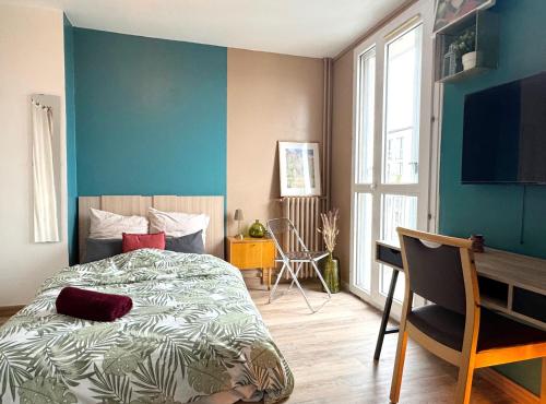 une chambre avec un lit et un mur bleu dans l'établissement Beau Studio proche de la gare de train, à Gagny
