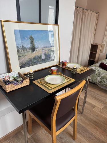 une table noire avec une chaise et une photo dans l'établissement Beau Studio proche de la gare de train, à Gagny