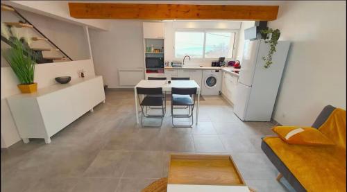 une cuisine et un salon avec une table et des chaises dans l'établissement Duplex à la campagne et coin jardin, à Savasse