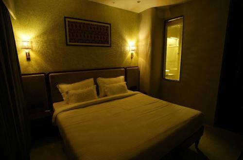 a bedroom with a bed with two pillows and a mirror at Hotel new manjushree in Pachmarhī