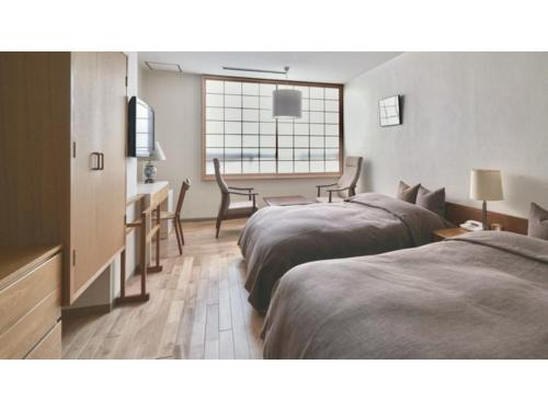 a hotel room with two beds and a dining room at Ryokan Akebono - Vacation STAY 91895v in Saga