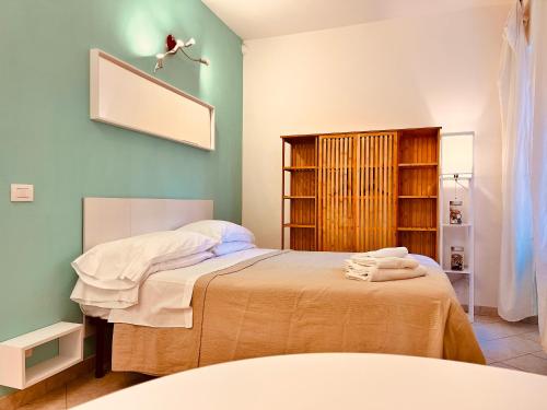 a bedroom with a bed with green walls at Le Case di Mia in Marciana Marina