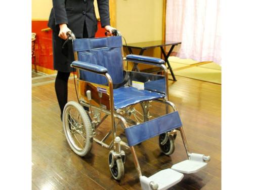 a woman is standing next to a blue wheelchair at Ryokan Akebono - Vacation STAY 91900v in Saga