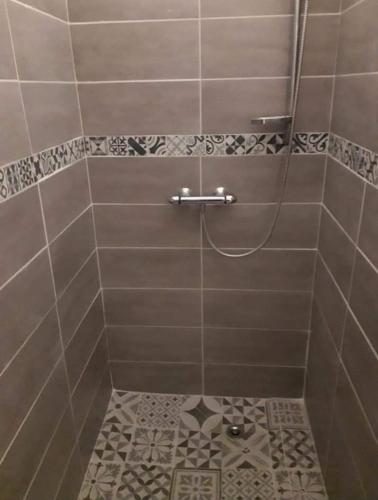 La salle de bains est pourvue d'une douche et de carrelage. dans l'établissement Ambiance chalet, à Prignac-et-Marcamps