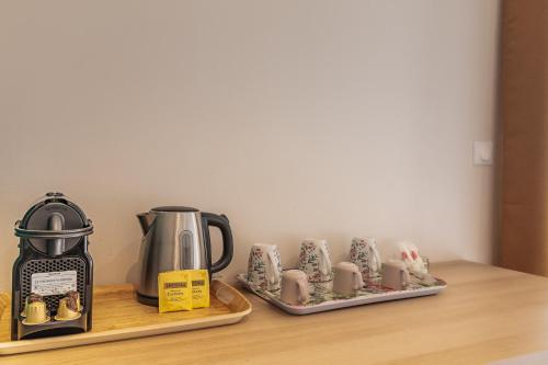 a kitchen counter with a coffee maker and coffee cups at Guest house in Montévrain
