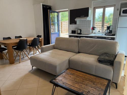 a living room with a couch and a table at Maison cosy du Bocage Ornais in Condé-sur-Sarthe