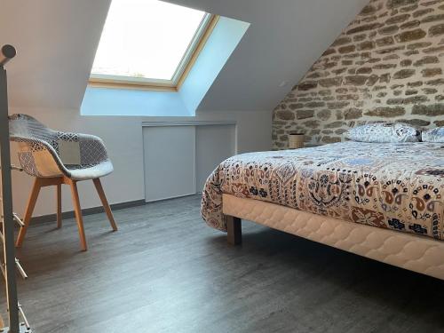 a bedroom with a bed and a brick wall at Maison cosy du Bocage Ornais in Condé-sur-Sarthe