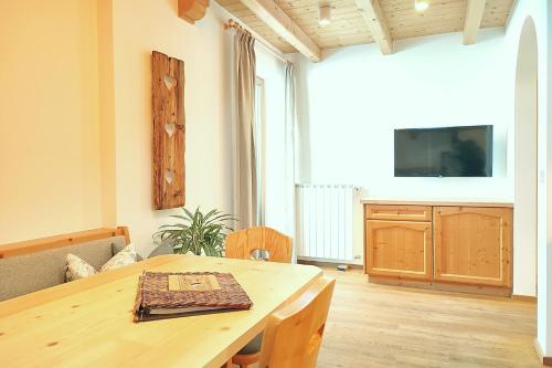 a living room with a wooden table and a television at Thalhofer Hof in Lazfons
