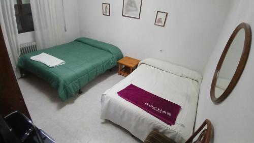 a hospital room with two beds and a mirror at Habitacion Privada Familiar Toledo in Toledo