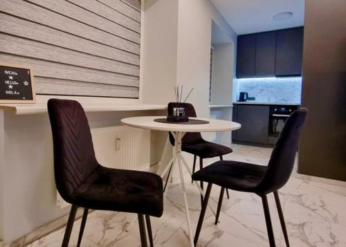 a kitchen with a table and two chairs and a table at Prie Žemaičio Pietinis in Raseiniai