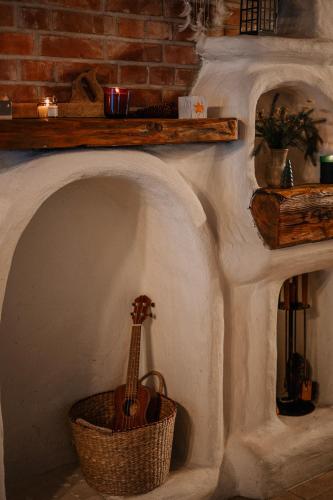 a guitar in a room with a brick wall at Przystanek Ropienka Leśniczówka in Ropienka