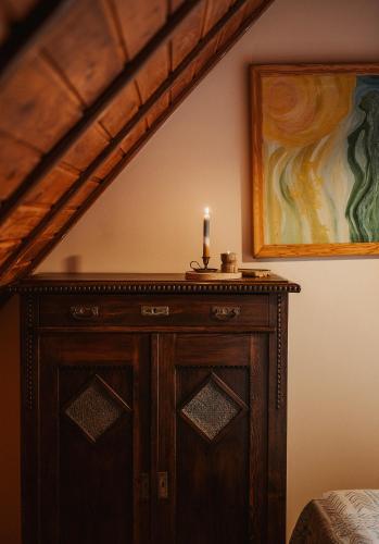a candle on top of a wooden cabinet in a room at Przystanek Ropienka Leśniczówka in Ropienka