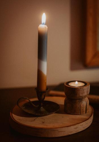 a candle on a wooden table with a candle holder at Przystanek Ropienka Leśniczówka in Ropienka