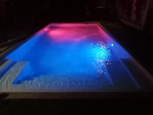 a pool with blue and pink lights on it at Eos affittacamere in Castelsardo