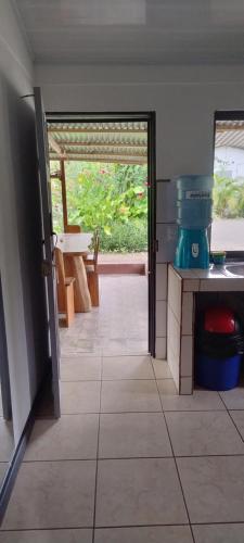a kitchen with a door open to a patio at Cabinas Los Tucanes in Cahuita