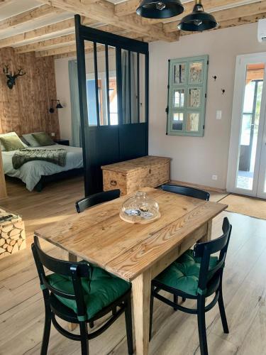 une salle à manger avec une table et des chaises en bois dans l'établissement Gîte La Maison Bleue, à Grosmagny