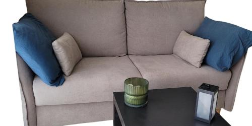 - un canapé avec des oreillers bleus et une table basse dans l'établissement Relax dans le Sud, à Montpellier