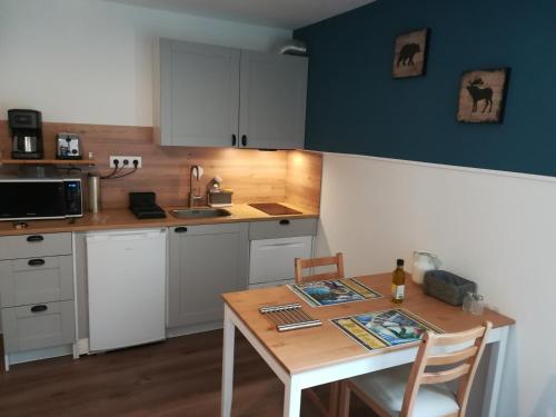 une cuisine avec une table en bois et une table et des chaises dans l'établissement Gite Roches Rousses, à Lans-en-Vercors