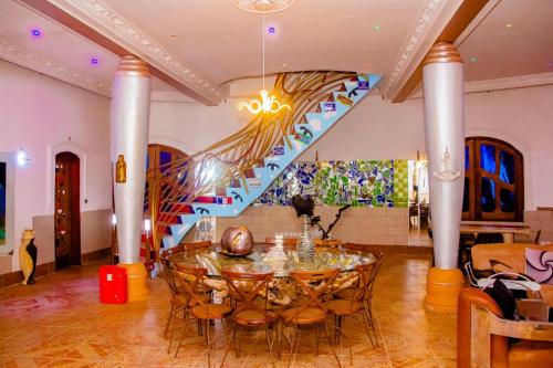 a dining room with a table and a staircase at Villa Gaudi (Gaoudi) in Akassato