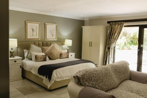 a bedroom with a bed and a couch at Meraki Country Manor in Lanseria