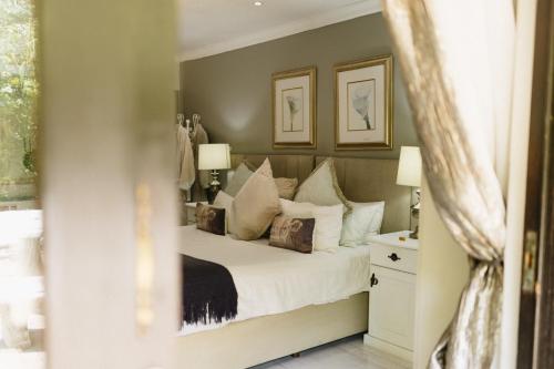 a bedroom with a bed with white sheets and pillows at Meraki Country Manor in Lanseria