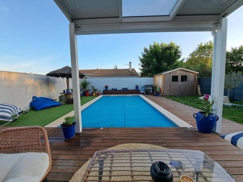 - une piscine dans un jardin avec une terrasse en bois dans l'établissement Maison au calme avec piscine, à Saint-Médard-en-Jalles