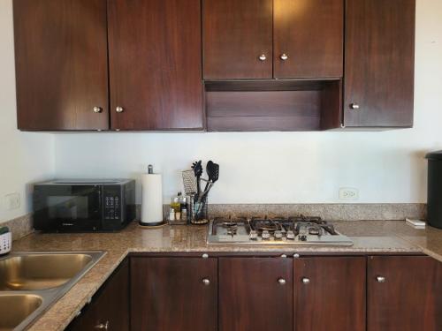 a kitchen with wooden cabinets and a stove top at Las Palmeras Cambutal in Cambutal