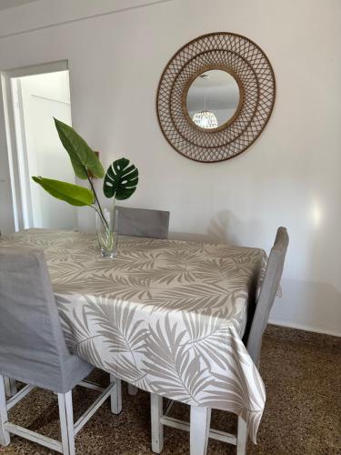 una mesa de comedor con una planta y un espejo en Depto Aqua 2, en Posadas
