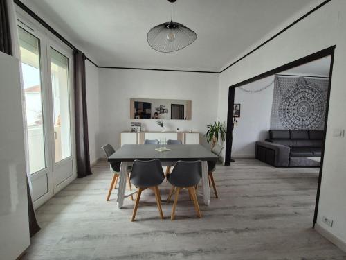 un salon avec une table, des chaises et un canapé dans l'établissement Appartement proche circuit 24h du Mans, au Mans