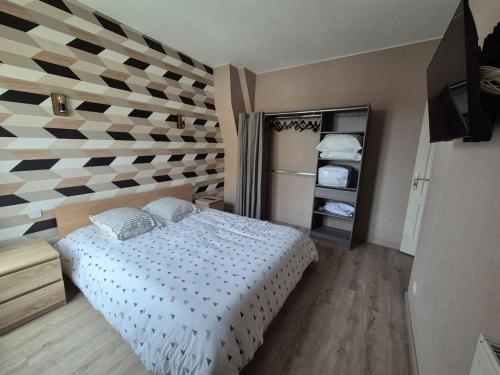 - une chambre avec un lit et un mur en damier dans l'établissement Appartement proche circuit 24h du Mans, au Mans