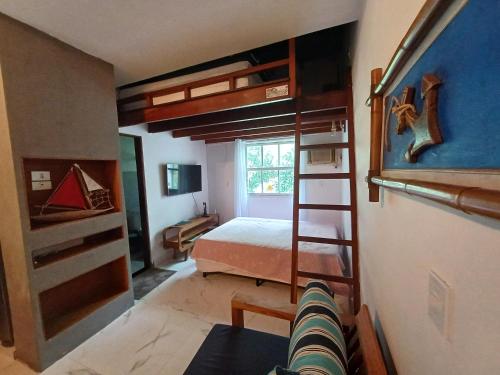 a bedroom with bunk beds and a bed and a ladder at Flat Maresias in São Sebastião