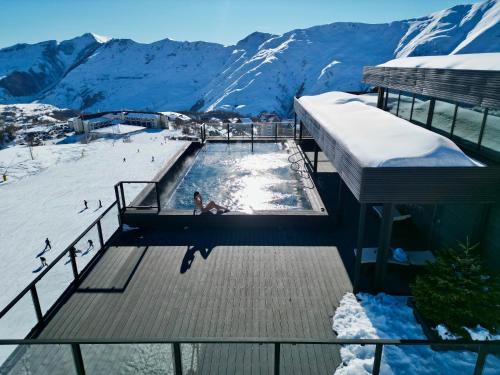 a person in a swimming pool on top of a mountain at Gudauri Loft Hotel in Gudauri