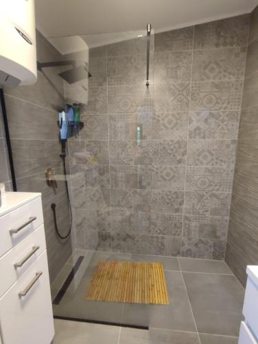 a bathroom with a shower with a yellow mat on the floor at Sarajevo Hills-POOL&JACUZZI private garden Home-Near Old Town in Sarajevo