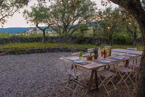 a long wooden table with chairs in a yard at Mas exceptionnel à Lagnes, Provence in Lagnes
