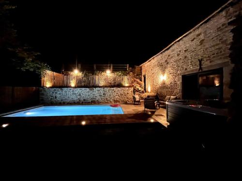 a swimming pool in a yard at night at La Grange aux Souvenirs - Piscine chauffée ,Jacuzzi et Terrain de pétanque in Grèzes