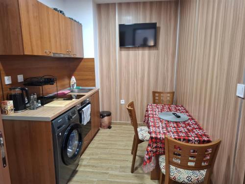 a small kitchen with a table and a kitchen with a washing machine at Двуспален апартамент Милена в хотел Росица,Пампорово in Pamporovo