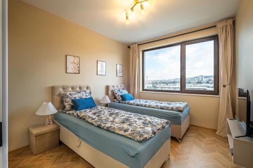 Dos camas en una habitación con ventana. en Luxury 2bedroom apartment in Complex Family Garden with FREE parking, en Varna