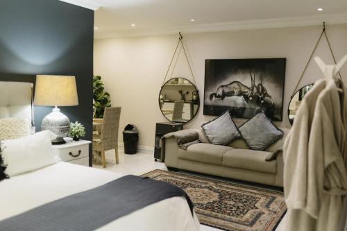 a bedroom with a bed and a couch at Meraki Country Manor in Lanseria