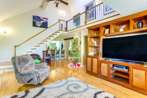 a living room with a large television and a christmas tree at 5 Mi to French Quarter Central NOLA Home with Decks in New Orleans